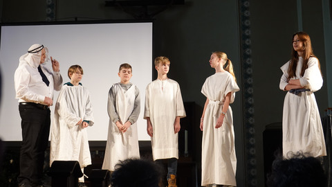 Sechs Personen in weißen Gewändern