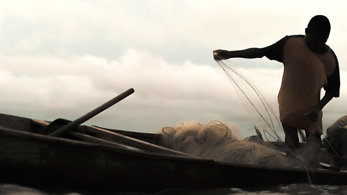 Junge auf einem kleinen Boot mit Fischernetz