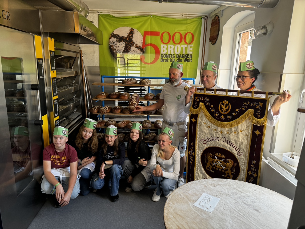 Gruppenfoto von Konfirmanden und Bäckermeistern vor den gebackenen Broten